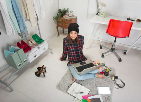 Young creative woman sitting in the floor with laptop の写真素材