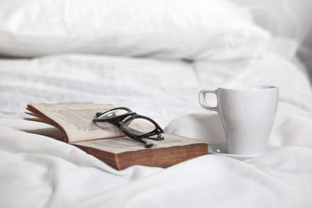 Young woman resting on the white bed の写真素材