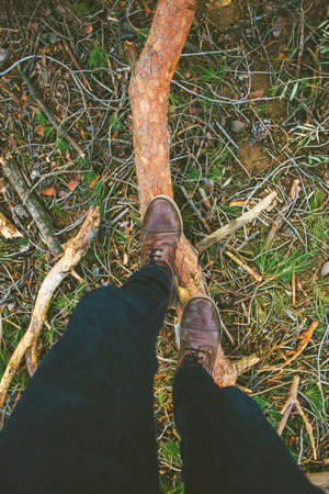 Overhead of man boots treading a pine log