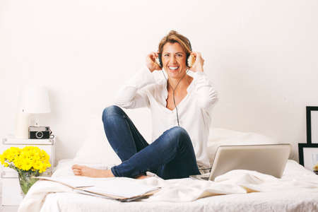 Business woman sitting in the white bed 