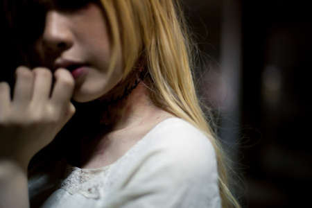 portrait of asian girl in white dress ready for halloween night,  low key pictureの写真素材