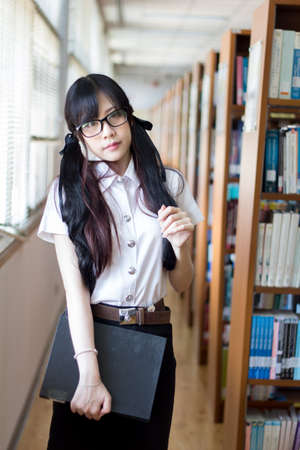 Asian girl in uniform studying in library