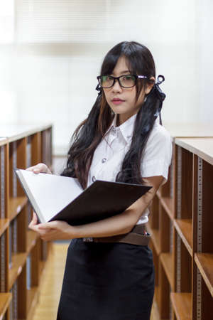Asian girl in uniform studying in libraryの写真素材