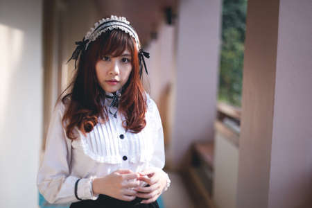 Charming Asian girl in japanese maid costume in film color styleの写真素材