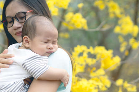 Asian mother holding her sleepy sonの写真素材