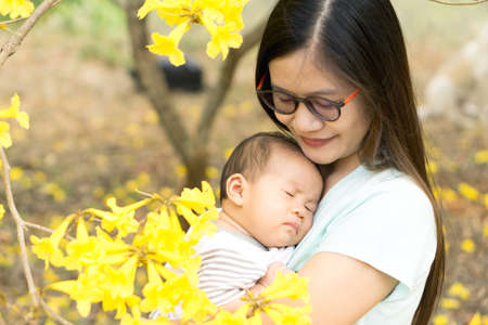 Asian mother holding her sleepy sonの写真素材
