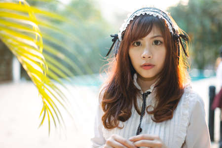 Charming Asian girl in japanese maid costume in film color styleの写真素材