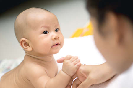 Asian baby  enjoy playing with mother handの写真素材