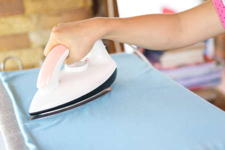 hand of woman ironing clothes on the tableの写真素材