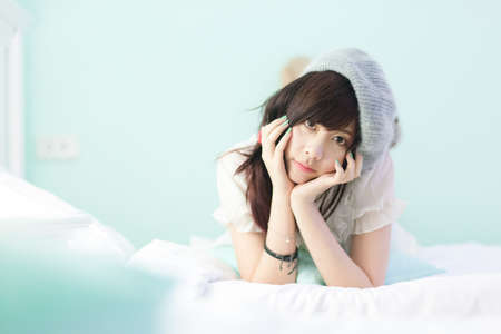 Charming Asian girl wearing pajamas on the bedの写真素材
