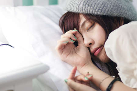 Charming Asian girl wearing pajamas on the bedの写真素材