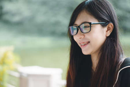 Asian girl with glasses playing with cat