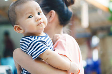 Asian mother and son on her shoulderの写真素材