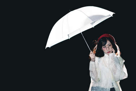 Charming Asian girl  with umbrella and raincoat at night