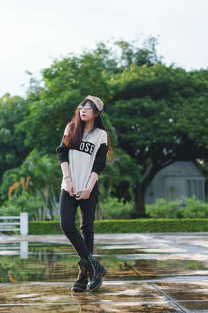 Charming Asian girl in hip hop style with sunset as background