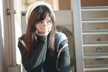 Portrait of charming Asian girl with hat and glasses in film tone style