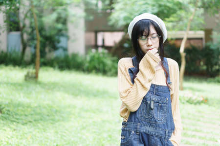 Charming Asian girl wearing jean overalls in the park