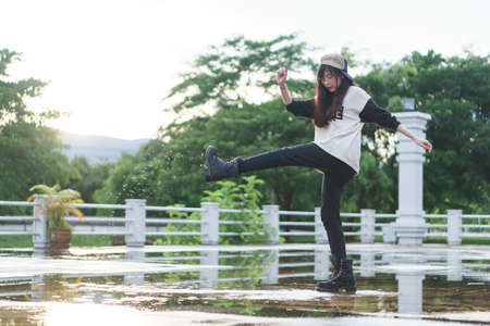 Charming Asian girl in hip hop style with sunset as background