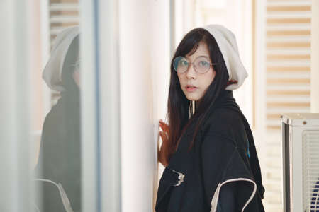 Portrait of charming Asian girl with hat and glasses in film tone styleの写真素材