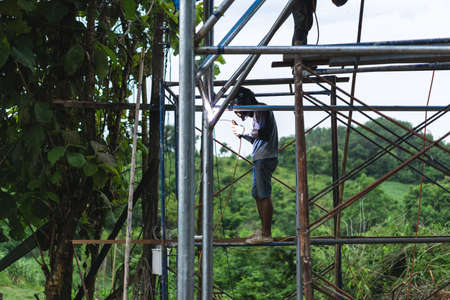 Thai labor welding on steel pipe for making  water tankの写真素材