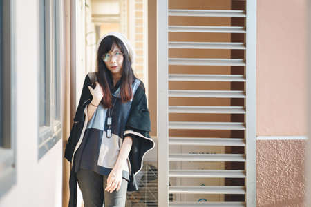 Portrait of charming Asian girl with hat and glasses in film tone styleの写真素材