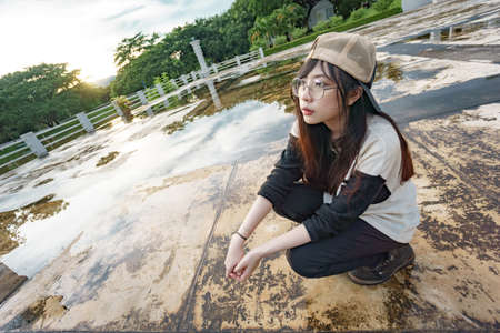 Charming Asian girl in hip hop style with sunset as background