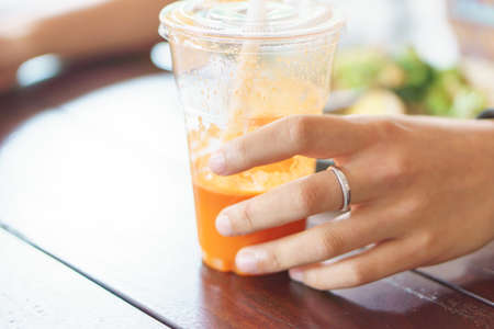 Thai tea with milk in glass with handsの写真素材