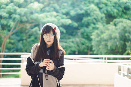 Portrait of charming Asian girl with hat and glasses in film tone style