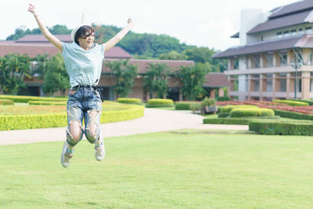 Portrait of charming Asian girl wearing jean overalls in the parkの写真素材