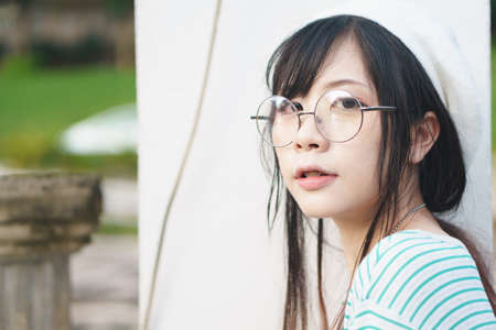 Portrait of charming Asian girl wearing jean overalls in the parkの写真素材