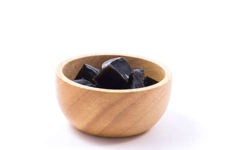 Grass jelly in wooden bowl isolated on white backgroundの写真素材
