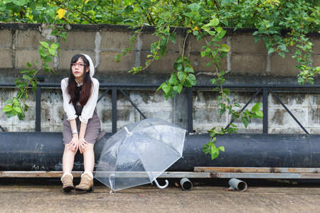 Charming Asian girl with umbrella in raining dayの写真素材