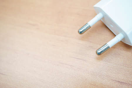 Electric plug on wooden background