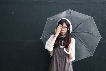 Charming Asian girl with umbrella in raining day
