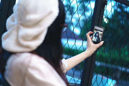 Charming Asian girl in casual wear taking selfie photoの写真素材