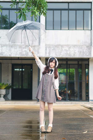 Charming Asian girl with umbrella in raining dayの写真素材