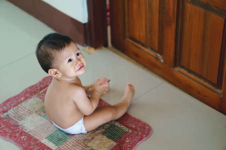 Cute Asian baby waiting for shower timeの写真素材