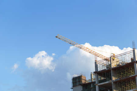 Construction crane at construction site with blue skyの写真素材