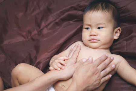 Mother applying baby powder to her son