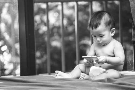 9 months Asian baby playing mobile phone