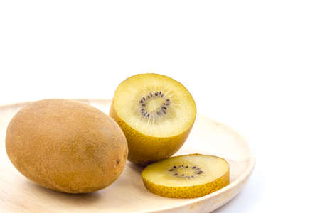 Golden kiwi fruit on wooden plateの写真素材