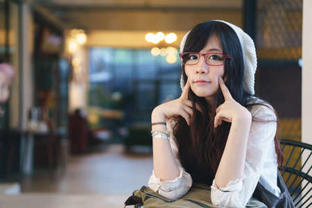 Portrait of charming Asian girl in a coffee shopの写真素材