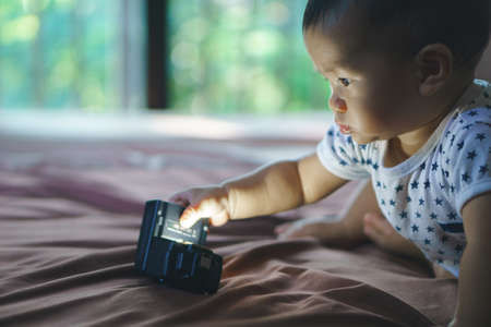 9 months Asian baby playing with led flashlight