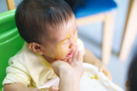9 months old Asian baby refuses eating medicine after mealの写真素材
