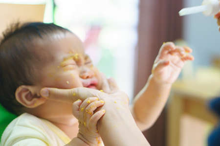 9 months old Asian baby refuses eating medicine after mealの写真素材