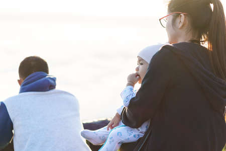 Asian Mother holding her baby to see the fog over mountainの写真素材