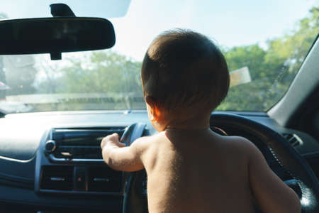 10 months Asian baby behind the steering wheelの写真素材