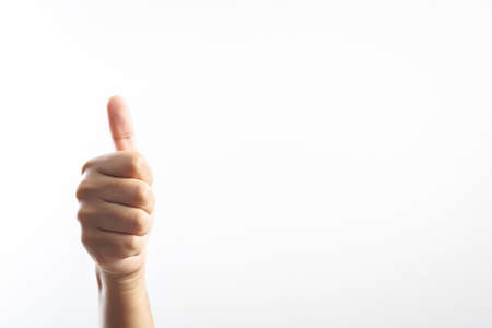 Thumb up hand sign on white backgroundの写真素材
