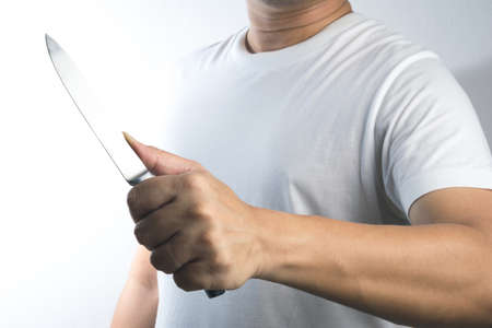 A hand holding knife on white backgroundの写真素材