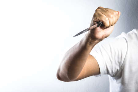 A hand holding knife on white backgroundの写真素材